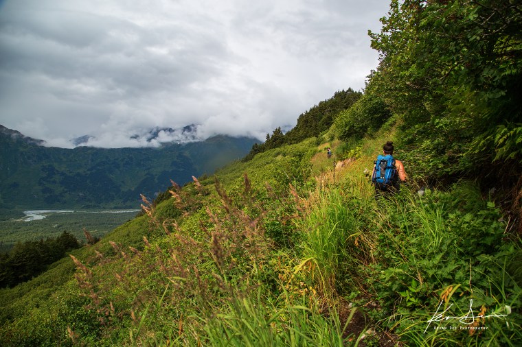 Molly climbs through the grasses on the Spencer Bench Hike. Photo by Kevan Dee.