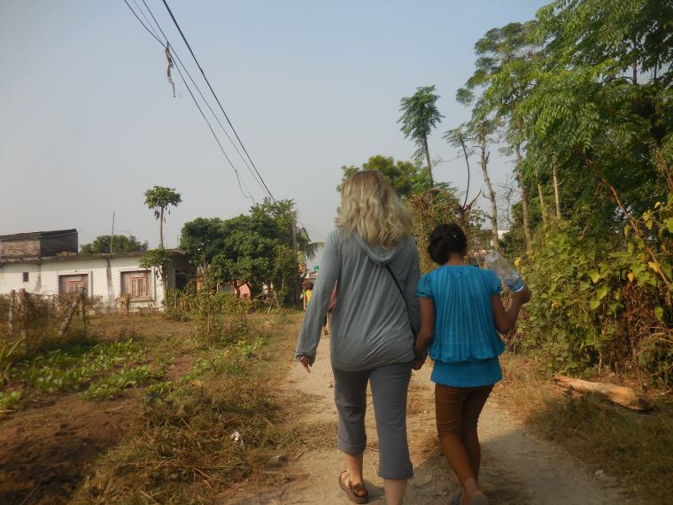Monika in Nepal with Jaminah, one of the orphaned children that Monika spent time with in Nepal. Here they are walking to the new school that the group Monika was in Nepal with raised money to pay for the kids to go to. Photo courtesy of Monika Fleming. 